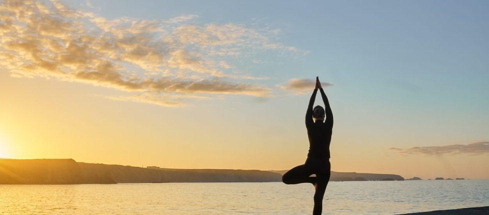woman doing yoga in front of ocean